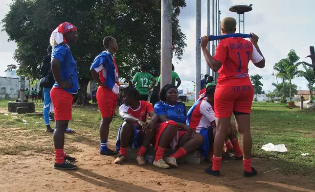 Women on the Girls of Aries kickball team, part of Liberia's professional kickball league, talk together before a match at the Samuel Kanyon Doe Stadium in Monrovia, Liberia, June 14, 2025. (AP Photo/Annie Risemberg)