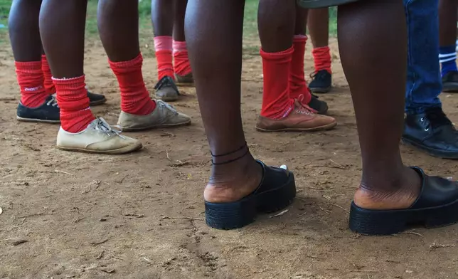 Women on the Girls of Aries kickball team, part of Liberia's professional kickball league, talk together before a match at the Samuel Kanyon Doe Stadium in Monrovia, Liberia, June 14, 2025. (AP Photo/Annie Risemberg)