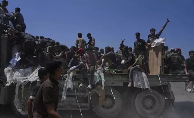 Palestinians hold onto an aid truck returning to Gaza City from the northern Gaza Strip, Sunday, July 27, 2025. (AP Photo/Abdel Kareem Hana)