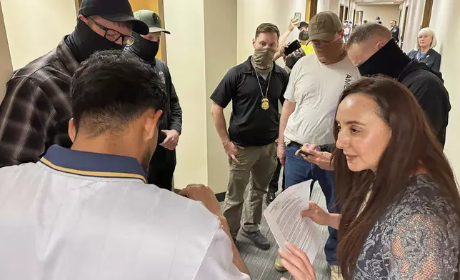 Immigration court volunteer Marjorie Miller gives guidance and support to a Colombian man who was about to be taken into custody by Immigration and Custom Enforcement officers in the hallway after his hearing with an immigration judge in Seattle, June 3, 2025. (AP Photo/Martha Bellisle)
