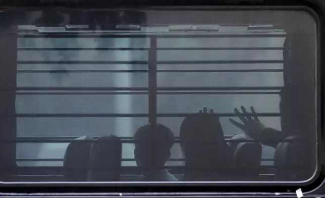 FILE - A family from Cuba is detained and loaded on to a bus with tinted windows and bars following an appearance at immigration court, June 11, 2025, in San Antonio. (AP Photo/Eric Gay, File)