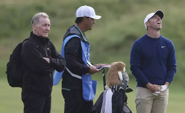 Rory McIlroy of Northern Ireland, right laughs, with caddy Harry Diamond, center, on the 11th fairway during a practice round for the 2025 British Open golf championship at the Royal Portrush Golf Club, Northern Ireland, Monday, July 14, 2025. (AP Photo/Peter Morrison)