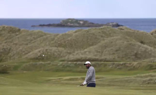 Scottie Scheffler of the United States plays onto the 16th green during a practice round for the 2025 British Open golf championship at the Royal Portrush Golf Club, Northern Ireland, Monday, July 14, 2025. (AP Photo/Peter Morrison)