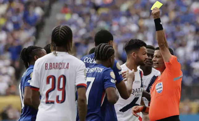 Referee Alireza Faghani shows the yellow card to Chelsea's Levi Colwill during the Club World Cup final soccer match between Chelsea and PSG in East Rutherford, N.J., Sunday, July 13, 2025. (AP Photo/Adam Hunger)