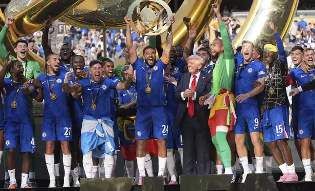 President Donald Trump, sixth from right, watches as Chelsea's Reece James (24) lifts the trophy following the Club World Cup final soccer match between Chelsea and PSG at MetLife Stadium in East Rutherford, N.J., Sunday, July 13, 2025. (AP Photo/Jacquelyn Martin)