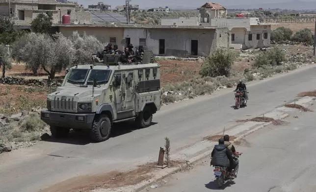 Syrian government security forces sit on their armored vehicle at Busra al-Harir village in Daraa, as they prepare to enter Sweida province where clashes erupted between Druze militias and Sunni Bedouin clans, southern Syria, Monday, July 14, 2025. (AP Photo/Omar Sanadiki)
