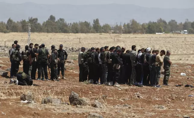 Syrian government security forces attend their noon prayer at Busra al-Harir village in Daraa, as they prepare to enter Sweida province where clashes erupted between Druze militias and Sunni Bedouin clans, southern Syria, Monday, July 14, 2025. (AP Photo/Omar Sanadiki)