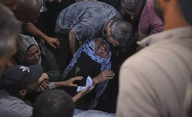 The mother of Anas Al-Basyouni mourns his loss shortly after he was killed while on his way to an aid distribution center, during his funeral at Shifa Hospital in Gaza City on Thursday, July 3, 2025. (AP Photo/Jehad Alshrafi)