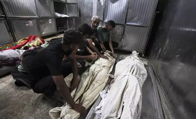 The bodies of Palestinians killed while on their way to an aid distribution center are prepared for burial at the morgue of Shifa Hospital in Gaza City, Thursday, July 3, 2025. (AP Photo/Jehad Alshrafi)
