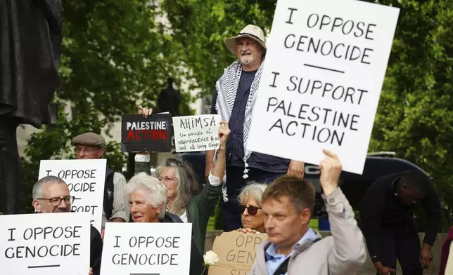 People take part in a protest in support of 'Palestine Action', organised by the Defend Our Juries group, in front of the Mahatma Gandhi statue in Parliament Square in London, England, Saturday, July 5, 2025. (Jeff Moore/PA via AP)