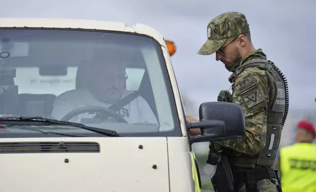 A Polish border police officer checks a vehicle at a checkpoint bordering Germany, in Slubice, Poland, Monday, July 7, 2025. (AP Photo/Ebrahim Noroozi)
