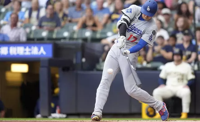 Los Angeles Dodgers' Shohei Ohtani hits a solo home run during the first inning of a baseball game against the Milwaukee Brewers, Tuesday, July 8, 2025, in Milwaukee. (AP Photo/Aaron Gash)