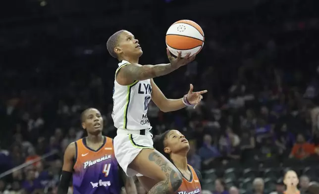 Minnesota Lynx guard Courtney Williams (10) drives past Phoenix Mercury forward Natasha Mack (4) and Mercury guard Monique Akoa Makani to score during the first half of a WNBA basketball game Wednesday, July 9, 2025, in Phoenix. (AP Photo/Ross D. Franklin)