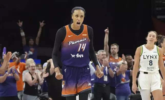 Phoenix Mercury forward DeWanna Bonner celebrates a Mercury score as Minnesota Lynx forward Alanna Smith (8) pauses on the court during the second half of a WNBA basketball game Wednesday, July 9, 2025, in Phoenix. (AP Photo/Ross D. Franklin)
