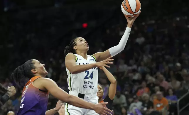 Minnesota Lynx forward Napheesa Collier (24) drives past Phoenix Mercury forward Alyssa Thomas, left, during the first half of a WNBA basketball game Wednesday, July 9, 2025, in Phoenix. (AP Photo/Ross D. Franklin)