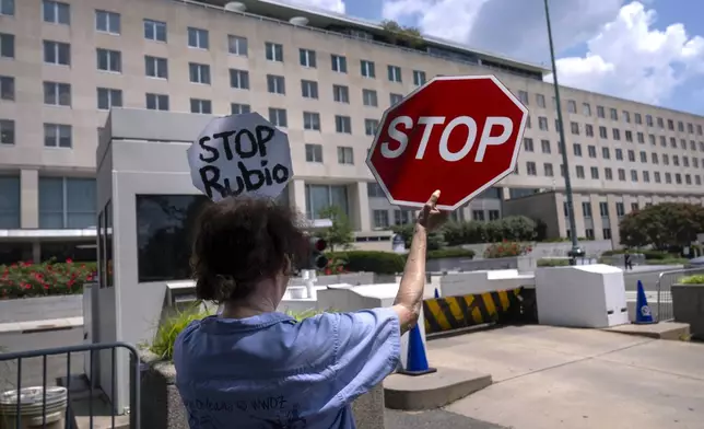 Former Foreign Service employee Anne Bodine of Arlington, Va., demonstrates against potential layoffs at the State Department, Friday, July 11, 2025, in Washington. (AP Photo/Mark Schiefelbein).