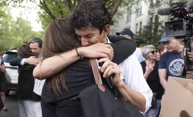 A fired State Department employee, left, is greeted outside of the Harry S. Truman Building, the headquarters of the State Department, in Washington, Friday, July 11, 2025. (AP Photo/Manuel Balce Ceneta)
