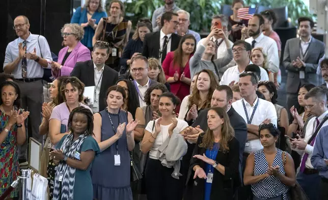 State Department employees applaud as their colleagues walk through the lobby of the State Department headquarters in the Harry S Truman Building, Friday, July 11, 2025, in Washington. (AP Photo/Mark Schiefelbein).