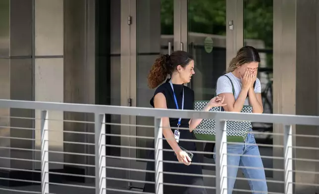 A woman reacts as she walks out of the State Department headquarters, Friday, July 11, 2025, in Washington. (AP Photo/Mark Schiefelbein).