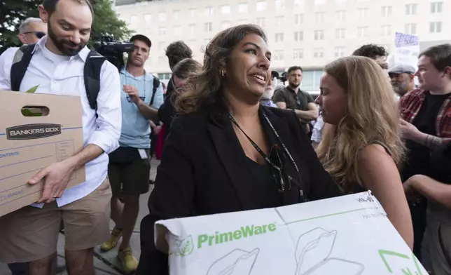 Fired State Department employees carry boxes out of the Harry S. Truman Building, the headquarters of the State Department, in Washington, Friday, July 11, 2025. (AP Photo/Manuel Balce Ceneta)