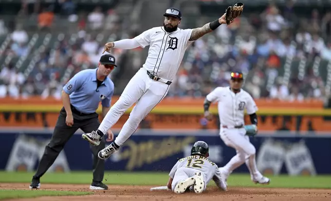Athletics' Max Schuemann, bottom, steals second base as Detroit Tigers second baseman Gleyber Torres (25) leaps to catch the throw from catcher Jake Rogers in the third inning of a baseball game, Thursday, June 26, 2025, in Detroit. (AP Photo/Lon Horwedel)