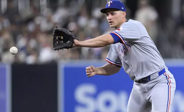 Texas Rangers shortstop Corey Seager fields a ball hit by San Diego Padres' Luis Arraez before throwing to first base for the out during the fifth inning of a baseball game, Sunday, July 6, 2025, in San Diego. (AP Photo/Orlando Ramirez)