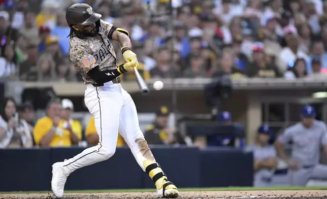 San Diego Padres' Fernando Tatis Jr. hits an RBI double during the fourth inning of a baseball game against the Texas Rangers, Sunday, July 6, 2025, in San Diego. (AP Photo/Orlando Ramirez)