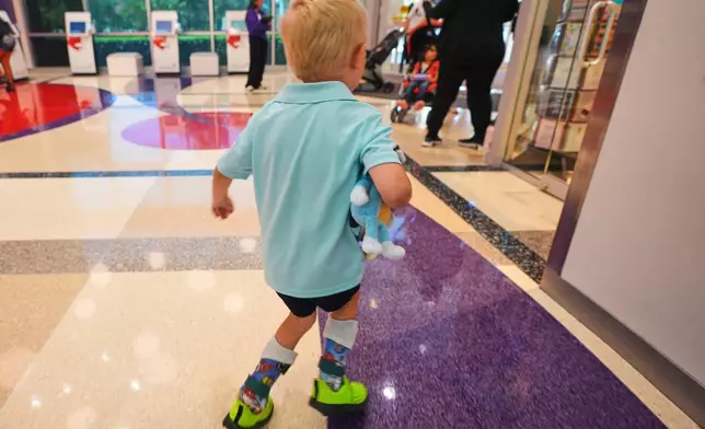 Four-year-old Rustin 'Rusty' Haugh who suffers from Combined Oxidative Phosphorylation Deficiency 11, or COXPD11, walks in a hospital lobby after a doctor's appointment in Dallas, Wednesday, July 23, 2025. (AP Photo/LM Otero)