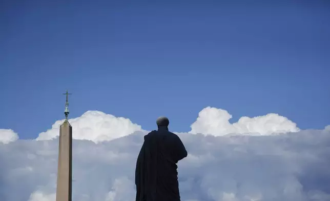 The statue of St. Peter is backdropped by clouds prior to the start of a welcome mass for the Youth Jubilee in St. Peter's Square at the Vatican, Tuesday, July 29, 2025. (AP Photo/Gregorio Borgia)