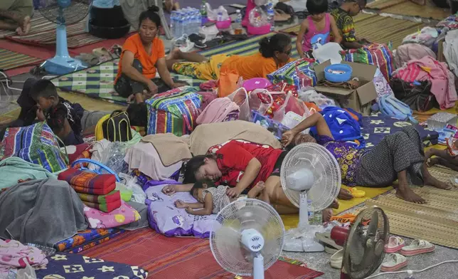 Thai residents who fled homes following the clashes between Thai and Cambodian soldiers, rest at an evacuation center in Surin province, Thailand, Wednesday, July 30, 2025. (AP Photo/Sakchai Lalit)