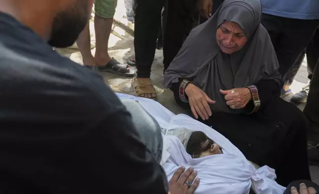 The mother of the Palestinian journalist Ismail Abu Hatab, who was killed in an Israeli strike on a cafe, mourns over the body of her son as she stands outside the Shifa Hospital, Gaza City, Monday, June 30, 2025.(AP Photo/Jehad Alshrafi)