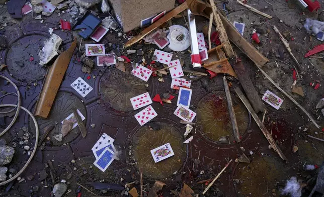 Blood, rubble, and a deck of cards lie scattered in a café after it was hit by an Israeli airstrike that killed more than 30 people near the port in Gaza City, Monday, June 30, 2025. (AP Photo/Jehad Alshrafi)