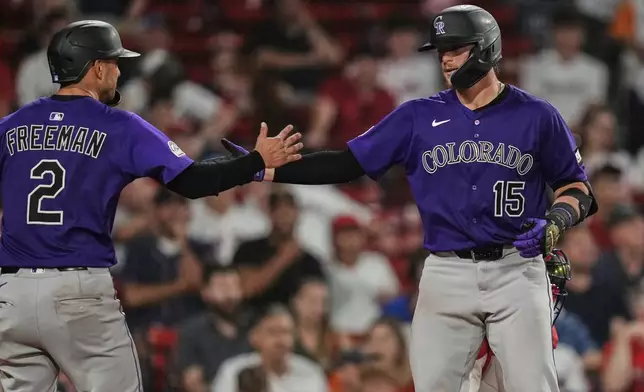 Colorado Rockies' Hunter Goodman (15) is congratulated by Tyler Freeman (2) after his two-run home run off Boston Red Sox pitcher Brayan Bello during the ninth inning of a baseball game at Fenway Park, Tuesday, July 8, 2025, in Boston. (AP Photo/Charles Krupa)