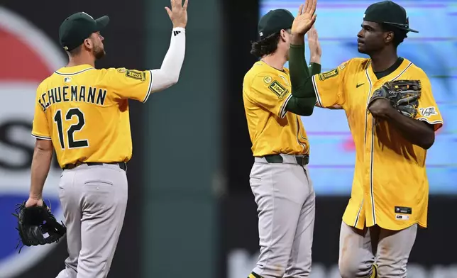 Athletics center fielder Denzel Clarke, right, is congratulated by second basemen Max Schuemann (12) after their team defeated the Cleveland Guardians in a baseball game, Saturday, July 19, 2025, in Cleveland. (AP Photo/David Dermer)