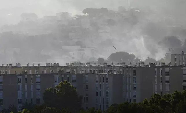 Smoke rises behind buildings during wildfire Tuesday, July 8, 2025 in La Catellane district of Marseille, southern France. (AP Photo/Lewis Joly)