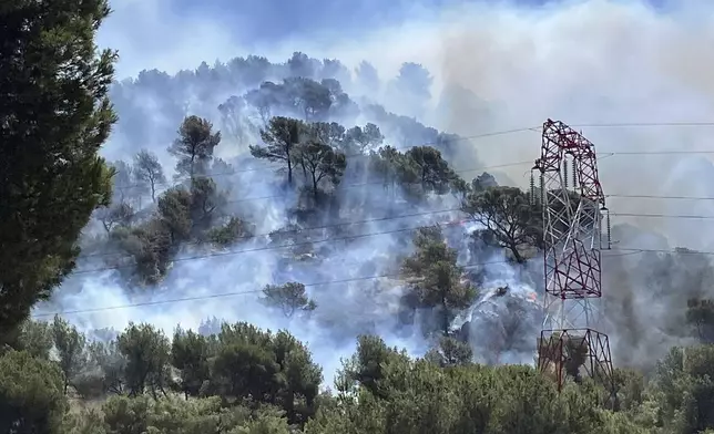 This photo provided by the fire brigade SDIS13, smoke rises during a wildfire in Pennes-Mirabeau, near Marseille, southern France, Tuesday, July 8, 2025. (SDIS13 via AP)