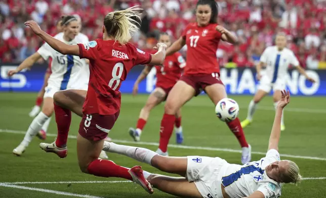 Finland 's Eveliina Summanen, on the ground, tries to tackle Switzerland's Nadine Riesen during the Euro 2025, group A, soccer match between Finland and Switzerland at Stade de Geneve in Geneva, Switzerland, Thursday, July 10, 2025. (AP Photo/Alessandra Tarantino)