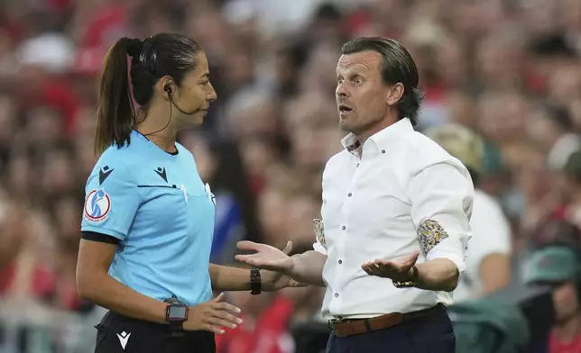 Finland head coach Marko Saloranta gestures next to fourth official Maria Sole Ferrieri Caputi during the Euro 2025, group A, soccer match between Finland and Switzerland at Stade de Geneve in Geneva, Switzerland, Thursday, July 10, 2025. (AP Photo/Alessandra Tarantino)