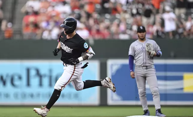 Baltimore Orioles' Tyler O'Neill, left, runs the bases after hitting a home run off Colorado Rockies pitcher Kyle Freeland during the first inning of a baseball game in Baltimore, Friday, July 25, 2025. (AP Photo/Terrance Williams)