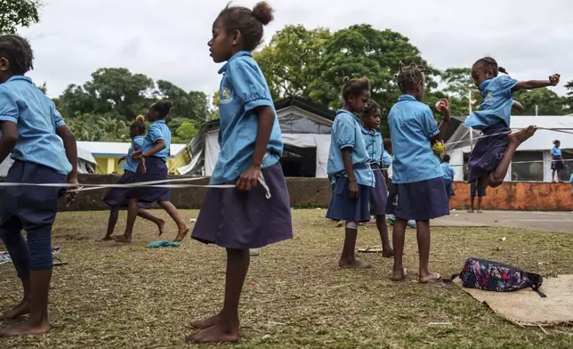 Students play outside tented classrooms at Sainte Jeanne D'Arc school in Port Vila, Vanuatu, Thursday, July 17, 2025. (AP Photo/Annika Hammerschlag)