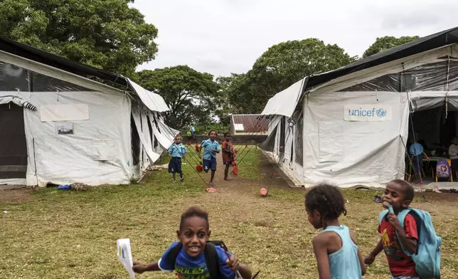 Students play outside tented classrooms at Sainte Jeanne D'Arc school in Port Vila, Vanuatu, Thursday, July 17, 2025. (AP Photo/Annika Hammerschlag)