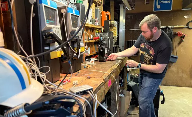 Patrick Schlott repairs an old payphone in his basement workshop on July 16, 2025 in Williamstown, Vt. (AP Photo/Amanda Swinhart)