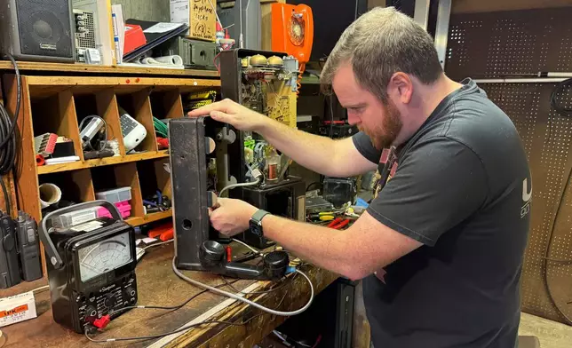 Patrick Schlott repairs an old payphone in his basement workshop on July 16, 2025, in Williamstown, Vt. (AP Photo/Amanda Swinhart)