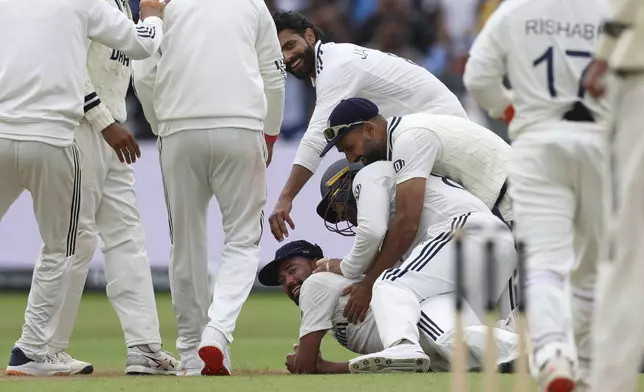 India's Mohammed Siraj, on ground, celebrates with teammates after taking the catch to dismiss England's Josh Tongue on day five of the second cricket test match between England and India at Edgbaston in Birmingham, England, Sunday, July 6, 2025. (AP Photo/Scott Heppell)