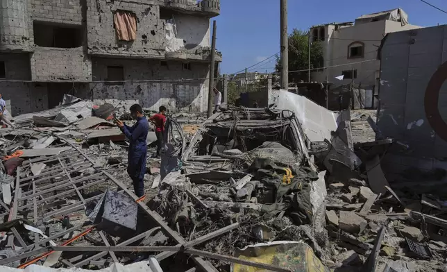 Palestinians inspect the wreckage of a gas station destroyed in an Israeli airstrike in Deir al-Balah, central Gaza Strip, Saturday, July 12, 2025. (AP Photo/Abdel Kareem Hana)