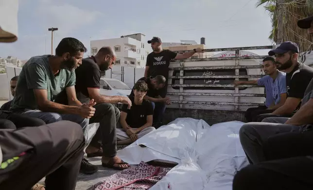 Mourners attend the funeral of their relatives who were killed in an Israeli bombardment, in Deir al-Balah, Gaza Strip, Saturday, July 12, 2025. (AP Photo/Abdel Kareem Hana)