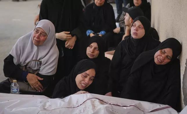 Mourners attend the funeral of their relatives who were killed in an Israeli bombardment, in Deir al-Balah, Gaza Strip, Saturday, July 12, 2025. (AP Photo/Abdel Kareem Hana)