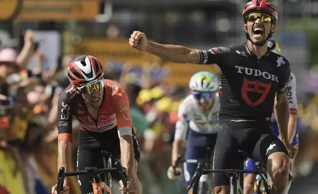 France's Julian Alaphilippe celebrates his third place when crossing the finish line with Spain's Carlos Rodriguez, left, during the fifteenth stage of the Tour de France cycling race over 169.3 kilometers (105.2 miles) with start in Muret and finish in Carcassonne, France, Sunday, July 20, 2025. (AP Photo/Thibault Camus)