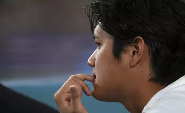Los Angeles Dodgers' Shohei Ohtani watches from the dugout during the fourth inning of a baseball game against the Milwaukee Brewers, Friday, July 18, 2025, in Los Angeles. (AP Photo/Mark J. Terrill)