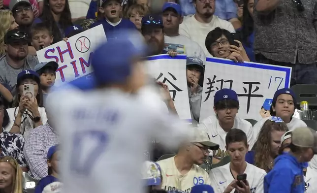 Fans cheer as Los Angeles Dodgers' Shohei Ohtani bats during the eighth inning of a baseball game against the Milwaukee Brewers, Monday, July 7, 2025, in Milwaukee. (AP Photo/Aaron Gash)